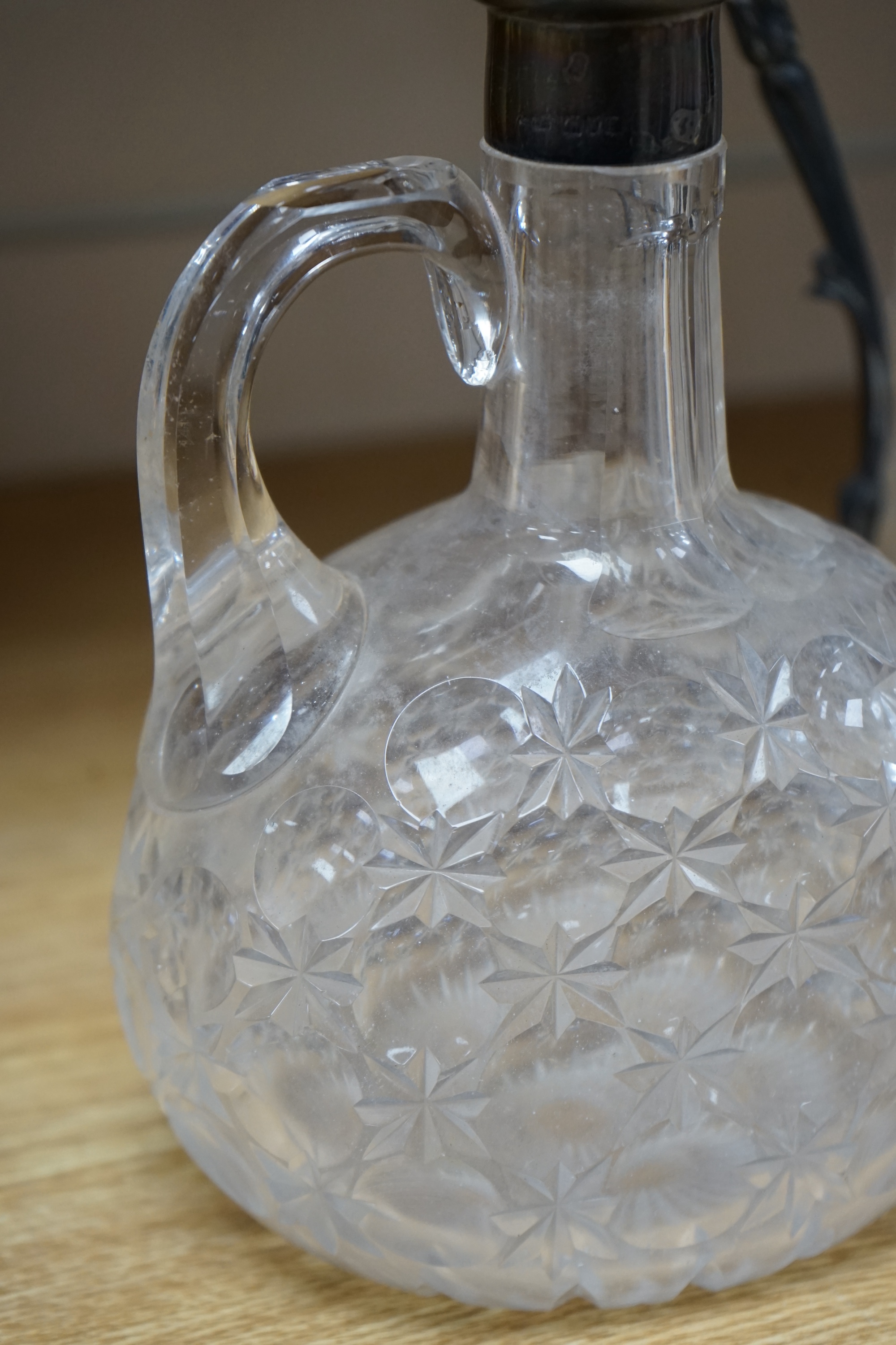 An Edwardian silver mounted cut glass decanter and stopper, London, 1901, height 26cm, together with a silver plate mounted cut glass claret jug. Condition - poor to fair